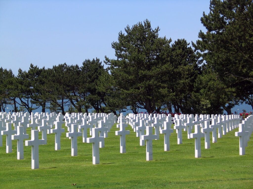 Rows of white crosses in a military cemetery, symbolizing remembrance and honor.